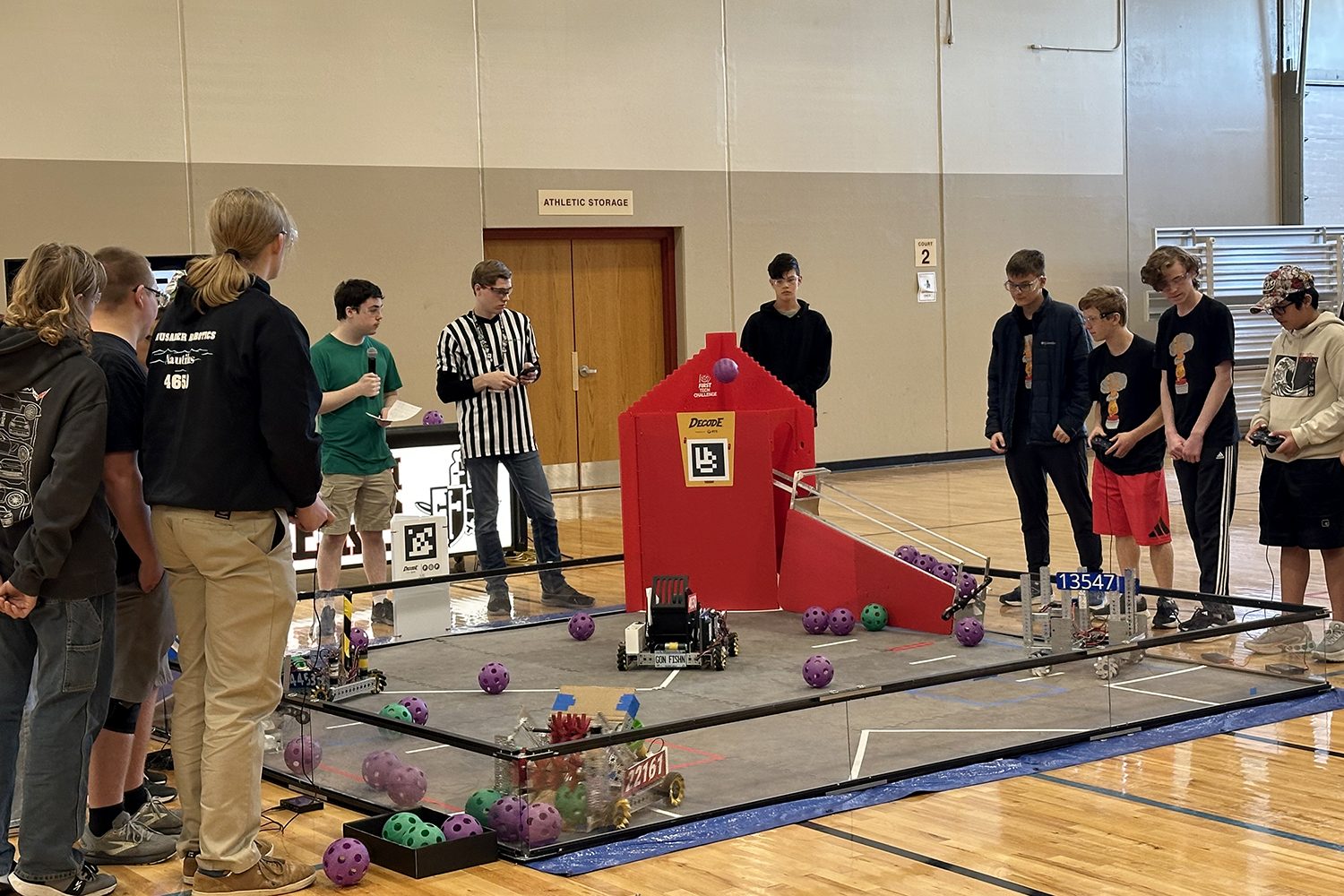 Crusader Robotics students driving their robots on the DECODE competition field, foam artifacts in play